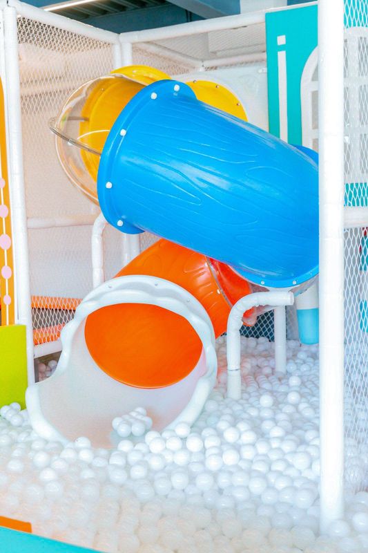 El tubo tobogán de colores sobre la piscina de pelotas